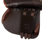 Close-up of a brown leather saddle with a brand label on a white background
